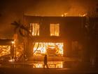 LOS ANGELES, CALIFORNIA - JANUARY 8: A firefighter watches the flames from the Palisades Fire burning homes on the Pacific Coast Highway amid a powerful windstorm on January 8, 2025 in Los Angeles, California.  The fast-moving wildfire has grown to more than 2900-acres and is threatening homes in the coastal neighborhood amid intense Santa Ana Winds and dry conditions in Southern California. (Photo by Apu Gomes/Getty Images)