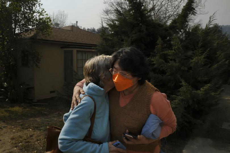 A neighbor consoles a woman who lost her home to the Eaton Fire. 