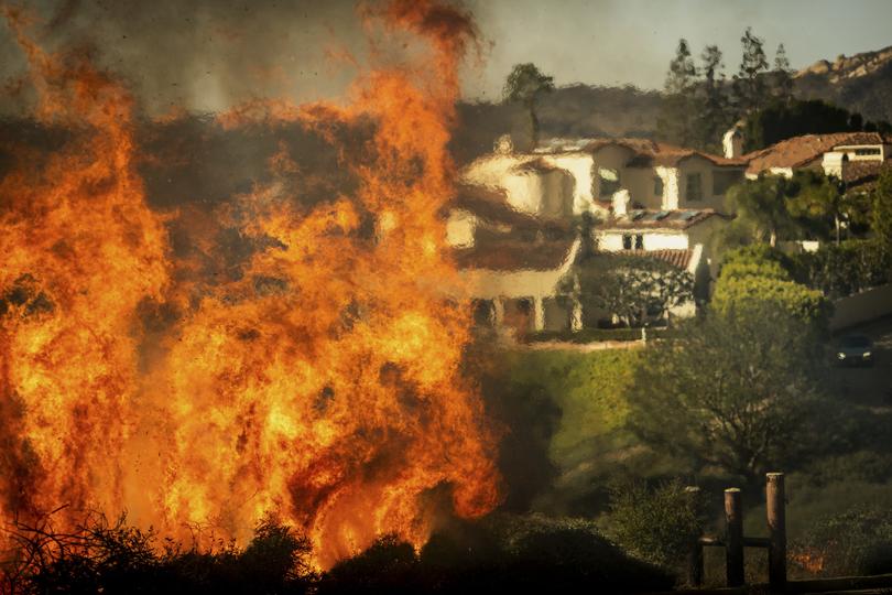 Flames rise as the Palisades Fire advances on homes in the Pacific Palisades neighborhood of Los Angeles, Tuesday, Jan. 7, 2025. 