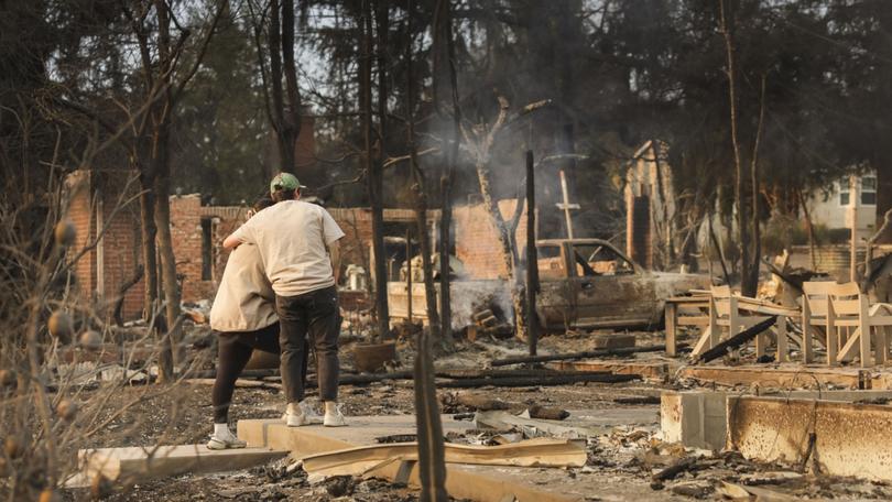 People embrace while looking over the remains of a home that was destroyed by the Eaton wildfire in the Altadena, California, USA, 09 January 2025. 