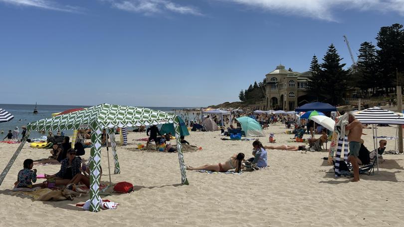 Cottesloe Beach is packed with beachgoers, cabanas and umbrellas on New Years Day, 2025