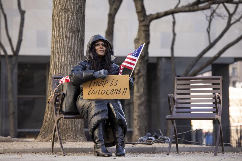 A supporter of US President-elect Donald Trump sits outside of New York Criminal Court during Trump's sentencing hearing.