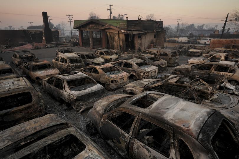 Cars are left charred inside a dealership in the aftermath of the Eaton Fire on Friday.