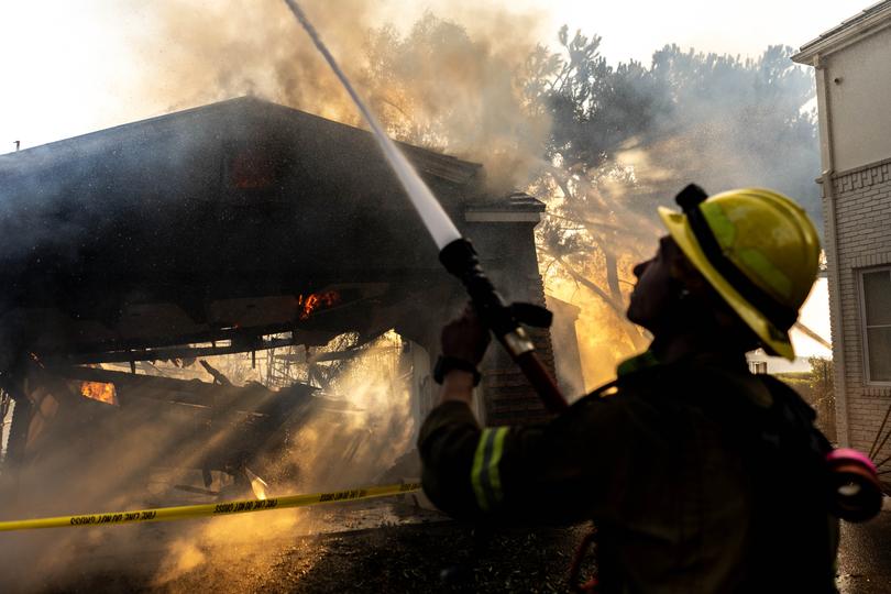 Orange County and Los Angeles County firefighters work to save homes in the Pacific Palisades neighborhood of Los Angeles on Thursday. 