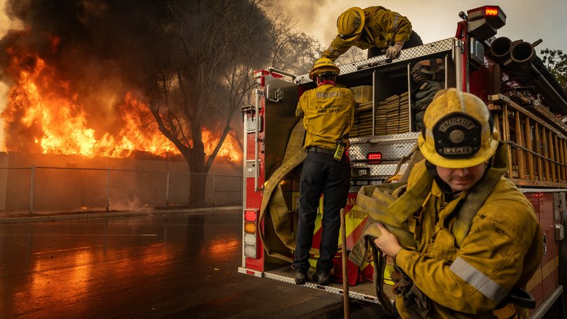 Firefighters work to extinguish a fire at the Altadena Golf Course on Thursday.