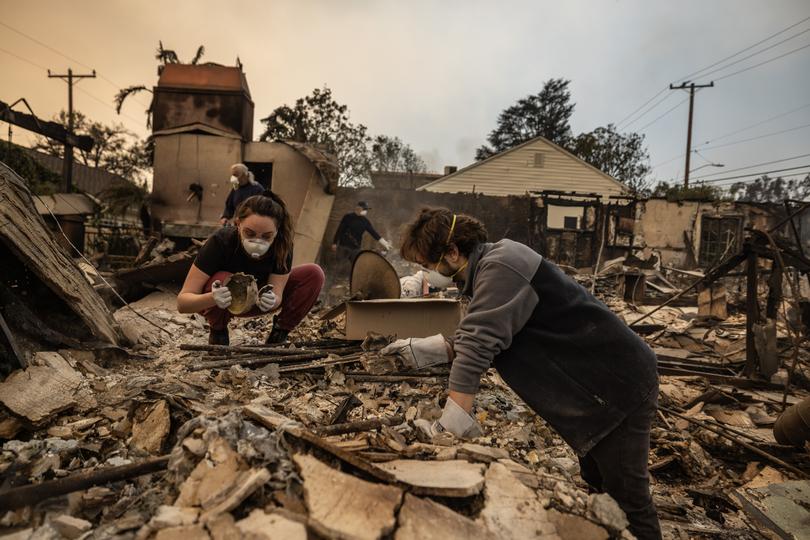 Ohan Derderian, right, and his wife, Ariana Derderian, look for treasured family belongings in the remains of her childhood home in Altadena, which was burned to the ground. 