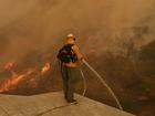 A firefighter hoses down flames as the Palisades Fire approaches in Mandeville Canyon.