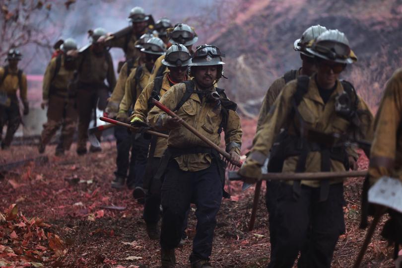 Firefighters hike into the Palisades wildfire in Los Angeles.