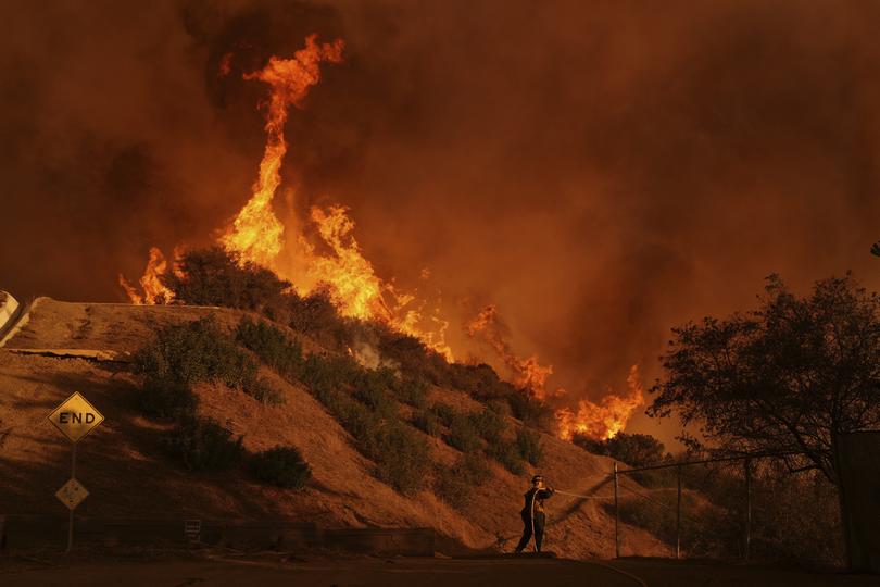 A firefighter battles the Palisades Fire in Mandeville Canyon Saturday, Jan. 11, 2025.