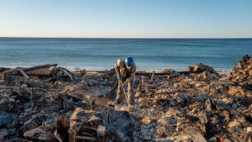 Patrick O'Neal sifts through his home after it was destroyed by the Palisades wildfire on January 13, 2025 in Malibu, California. 