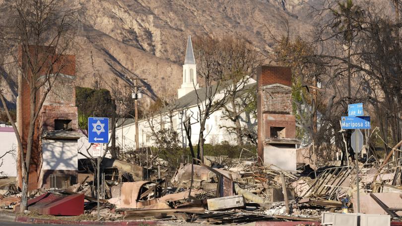 The undamaged First Church of Christ, Scientist is seen through damage and debris from the Eaton Fire.