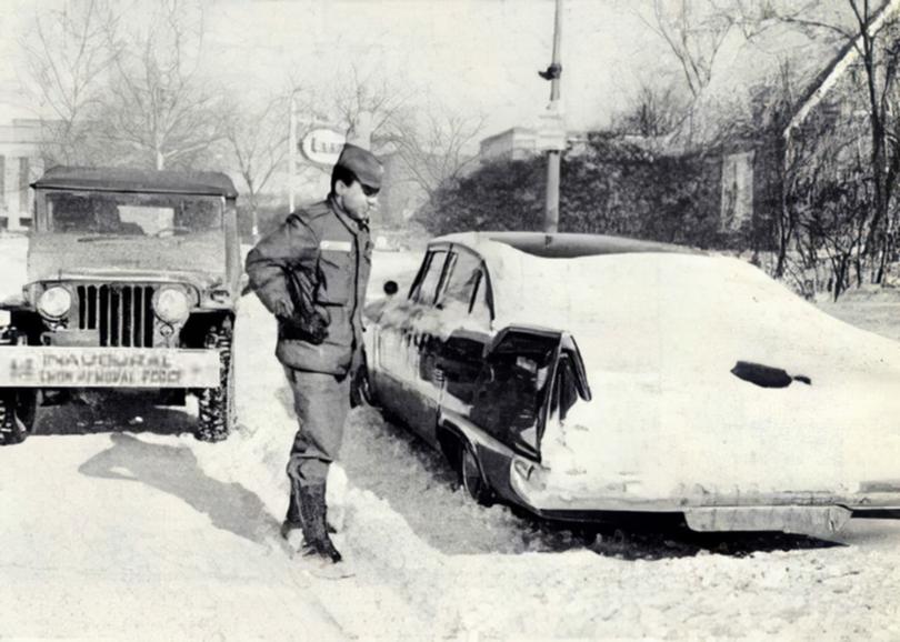 A soldier from U.S. Army Corps of Engineers' inaugural snow removal force prepares to move a car abandoned from the snowstorm on the eve of John F. Kennedy's inauguration in 1961. U.S. Army Corps of Engineers