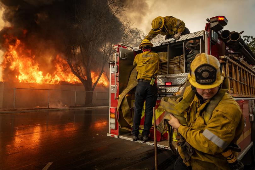 Firefighters work to extinguish a fire at the Altadena Golf Course on Thursday. 