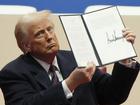 President Donald Trump holds up an executive orders after signing it at an indoor Presidential Inauguration parade event in Washington, Monday, Jan. 20, 2025.