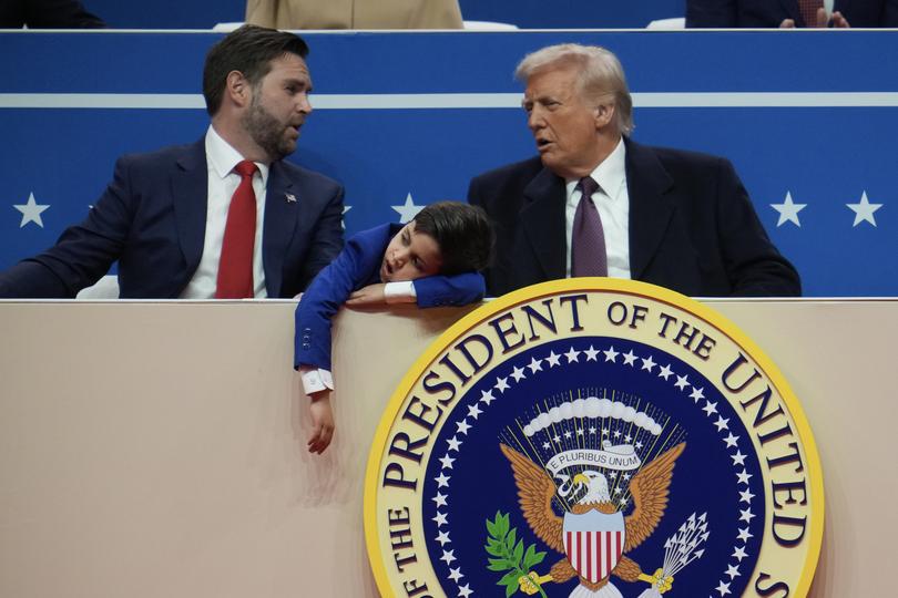 US Vice President J.D. Vance, his son Ewan, 7, and US President Donald Trump  Trump talk during an indoor inauguration parade at Capital One Arena.