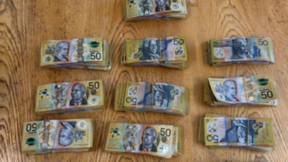 A shopping bag of money has been found in scrubland near a busy highway.