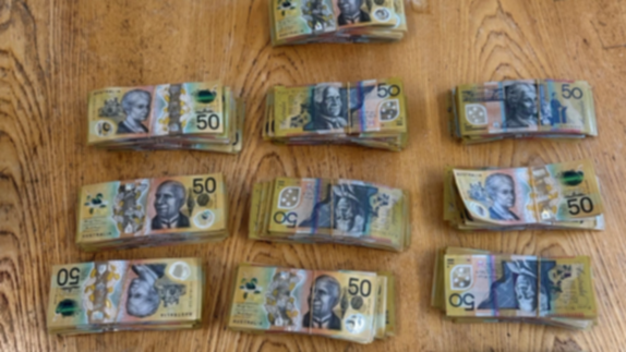 A shopping bag of money has been found in scrubland near a busy highway. 