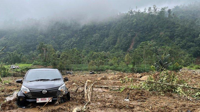 The wreckage of a car is stuck in the mud at an area affected by a landslide following a flash flood which killed a number of people in Pekalongan, Central Java.