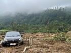 The wreckage of a car is stuck in the mud at an area affected by a landslide following a flash flood which killed a number of people in Pekalongan, Central Java.