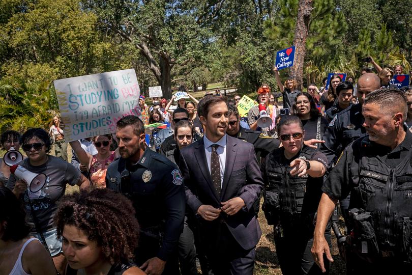 Christopher Rufo walks through protesters on his way out of a bill signing event featuring Florida Governor Ron DeSantis.