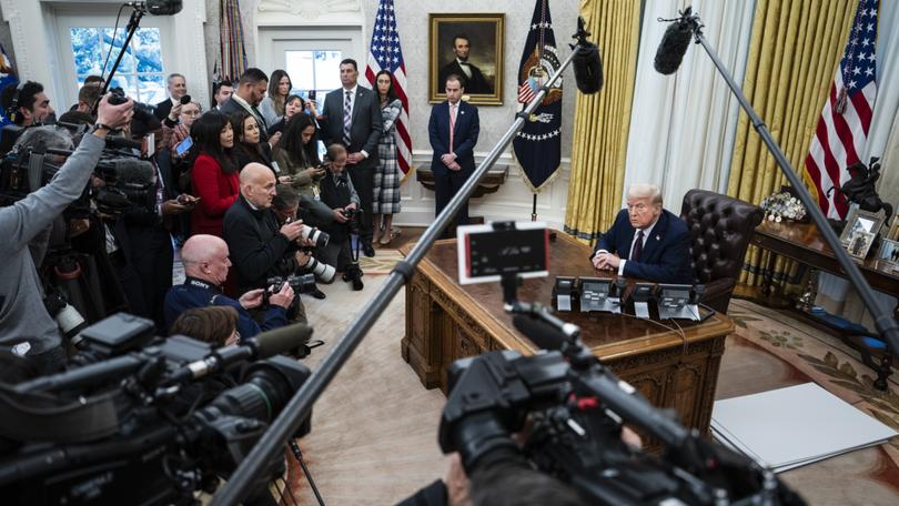 President Donald Trump speaks with reporters and signs executive orders in the Oval Office on Thursday.