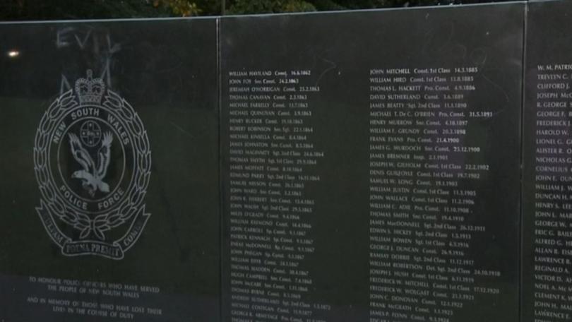 The words 'evil' and 'dogs' have been etched onto a police memorial wall along the names of fallen members of the force.