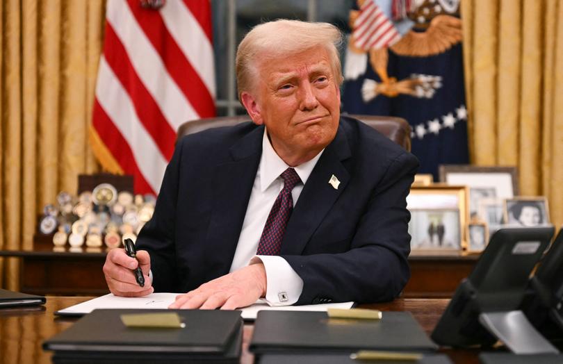 US President Donald Trump signs executive orders in the Oval Office of the White House in Washington.