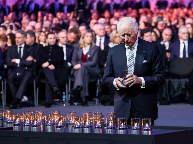 King Charles leaves candles by a symbolic nazi transport wagon in the Auschwitz - Birkenau Museum at the former Nazi German Auschwitz Concentration camp.