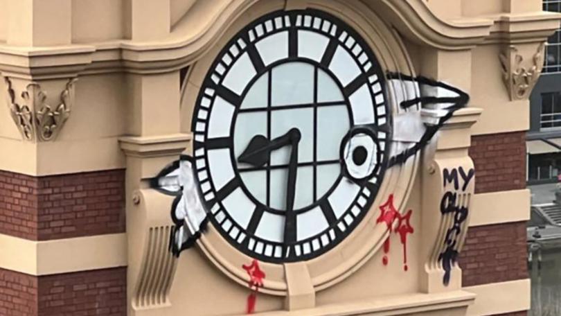 Police will allege the man scaled and defaced heritage-listed Flinders St Railway Station clock. (HANDOUT/METRO)