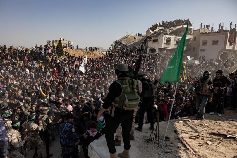 Palestinian civilians and militants gather for the release of hostages, as part of a ceasefire and prisoner exchange deal between Hamas and Israel.