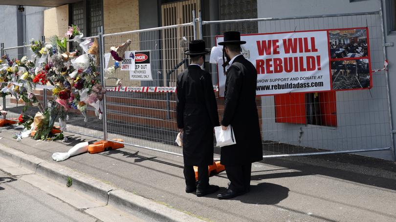 People gather outside the Adass Israel Synagogue after a firebombing in Melbourne.