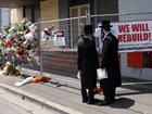 People gather outside the Adass Israel Synagogue after a firebombing in Melbourne.