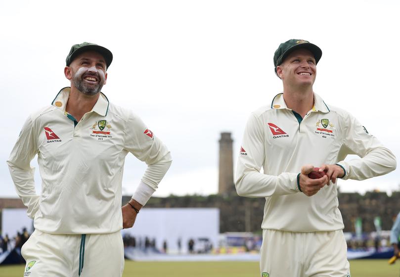 Nathan Lyon and Matthew Kuhnemann of Australia leave the ground as rain interrupts play.