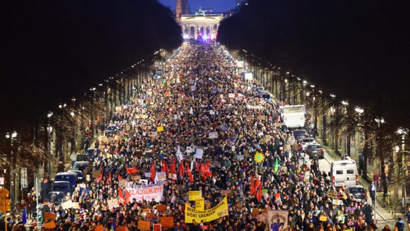 Tens of thousands of demonstrators marched in front of the Brandenburg Gate in Berlin.