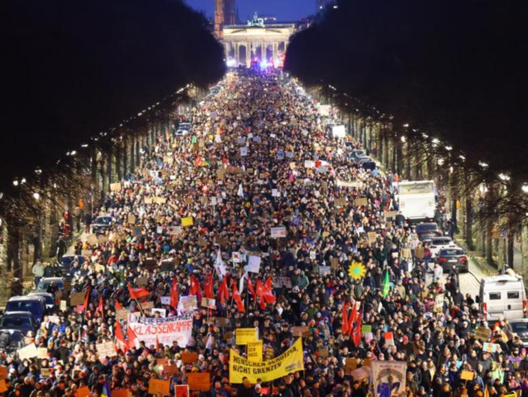 Tens of thousands of demonstrators marched in front of the Brandenburg Gate in Berlin.