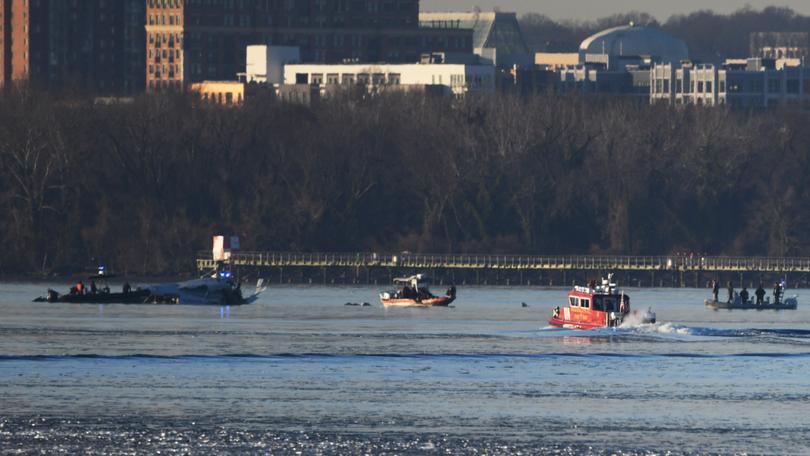 Emergency response units search the crash site near Reagan National Airport last week. MUST CREDIT: Astrid Riecken for The Washington Post