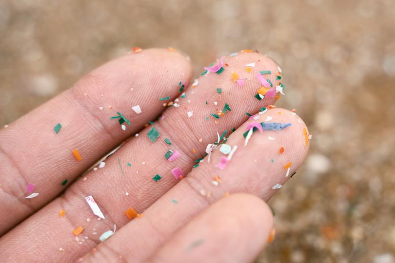 Close up side shot of microplastics on a person’s hand.