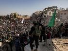 Palestinian civilians and militants gather for the release of hostages, as part of a ceasefire and prisoner exchange deal between Hamas and Israel, in Khan Younis, southern Gaza Strip, 30 January 2025. 