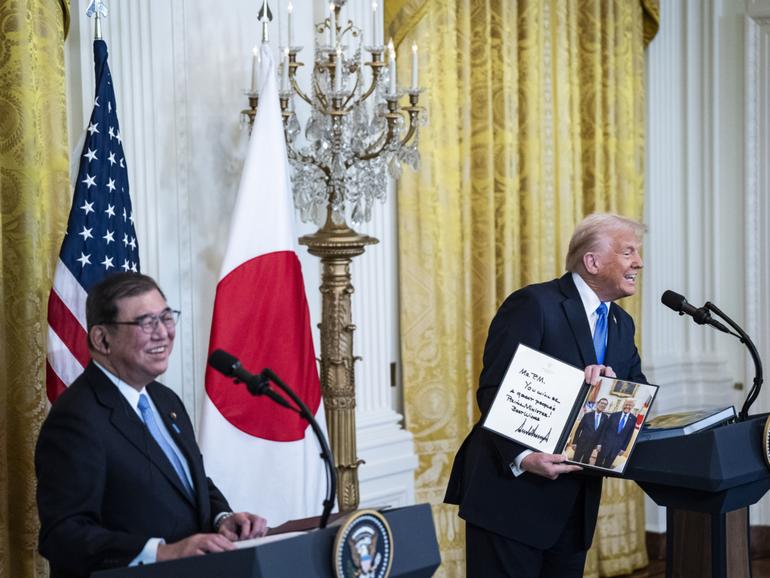 President Donald Trump gives a signed photo to Japanese Prime Minister Shigeru Ishiba during a news conference in the East Room at the White House on Friday. MUST CREDIT: Jabin Botsford/The Washington Post