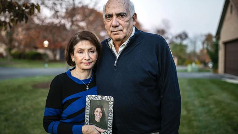 Josh and Sandee Greenberg pose for a portrait with a picture of their daughter Ellen in November 2021.