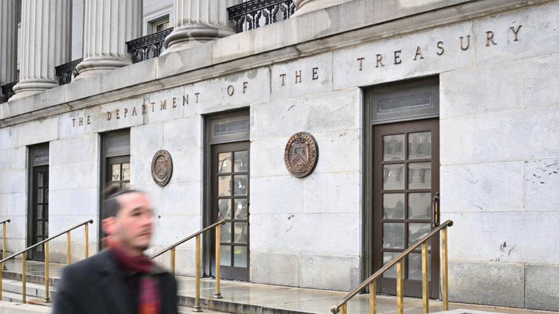 A man walks past the US Treasury in Washington, DC, on February 6, 2025. Opponents to US President Donald Trump say he allowed Elon Musk -- the world's richest man and a major government contractor -- to break the law by accessing US Treasury payment systems that send out trillions of dollars and hold a welter of sensitive personal data. (Photo by Mandel NGAN / AFP)