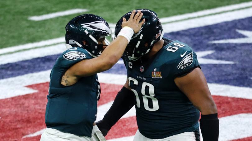 Jalen Hurts celebrates a touchdown with Jordan Mailata.