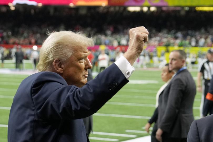 President Donald Trump gestures to the crowd before the start of the Super Bowl.