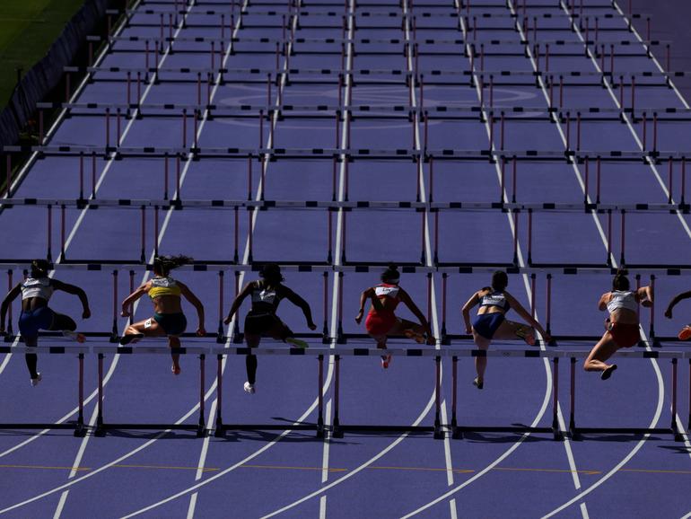 Athletes competing in the Women's 100m Hurdles Repechage at the Paris Olympics.