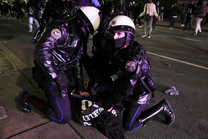 Police make an arrest after issuing a midnight dispersal order for Philadelphia Eagles fans celebrating the team's victory over the Kansas City Chiefs in Super Bowl LIX in the streets near Philadelphia City Hall in Philadelphia, Pennsylvania.