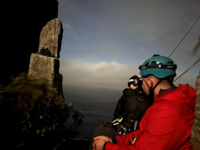 Two climbers have been rescued overnight after getting stuck at the top of a 60m-high rock formation in Tasmania. 