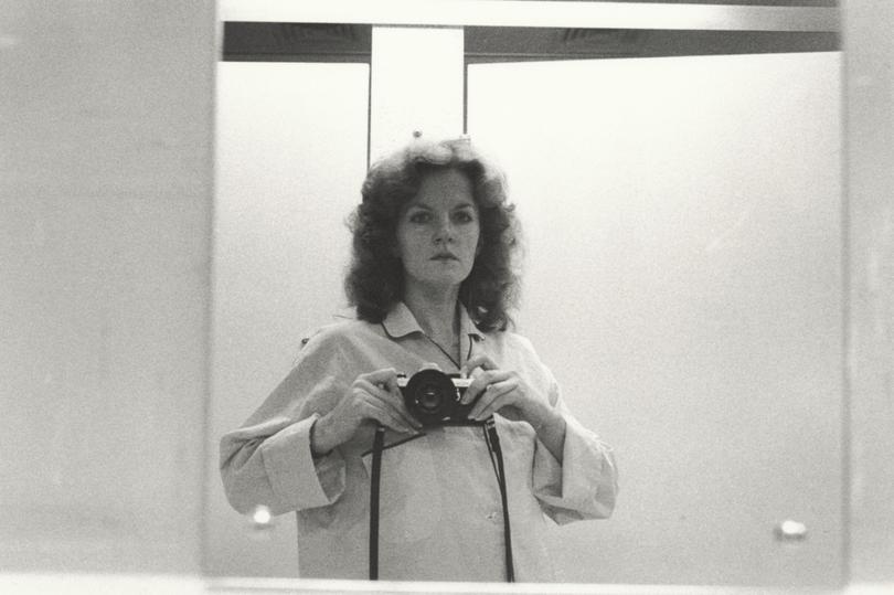 1/2 length self portrait in  mirror, wearing pyjama shirt, camera at shoulder height (1979) by Carol Jerrems.