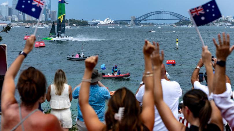 Spectators on Shark Island watch the action as Australia SailGP Team helmed by Tom Slingsby crosses the finish line to win on Race Day 1 of the KPMG Australia Sail Grand Prix in Sydney.