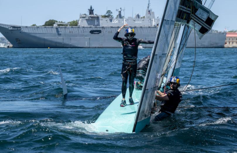 Taylor Canfield, driver of USA SailGP Team, stands on the hull after the USA SailGP Team F50 catamaran capsized.