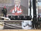 A Hamas militant stands on stage near coffins during the handover of deceased hostages Oded Lifschitz, Shiri Bibas and her two children Kfir and Ariel Bibas.